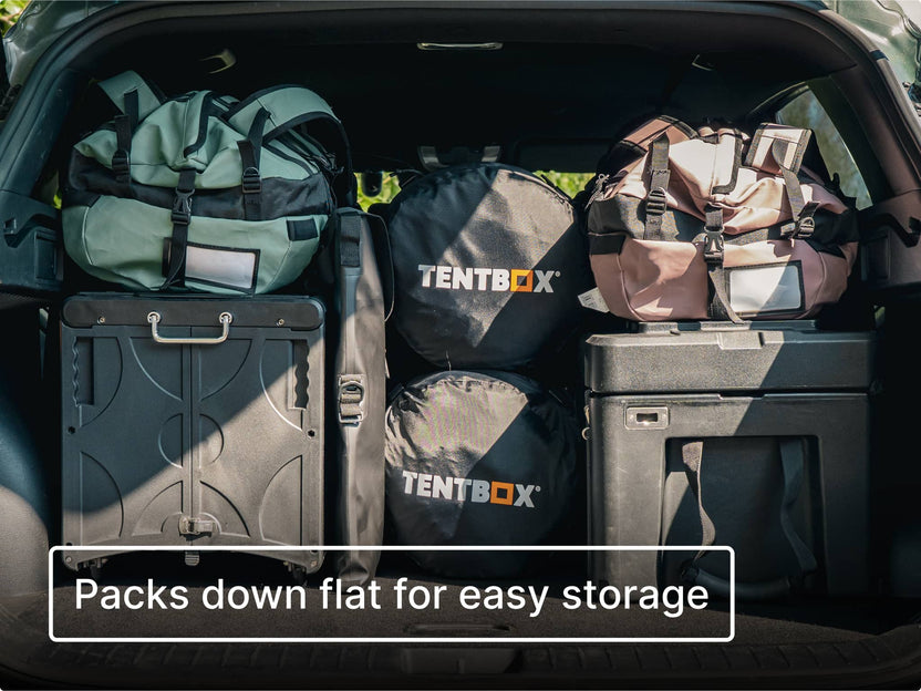 Car boot packed neatly with luggage, TentBox sleeping bags, KitchenBox and the TentBox CoolBag with text 'Packs down flat for easy storage'.