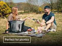 Two people sitting on a picnic blanket in a park with the TentBox CoolBag and text 'Perfect for picnics'.