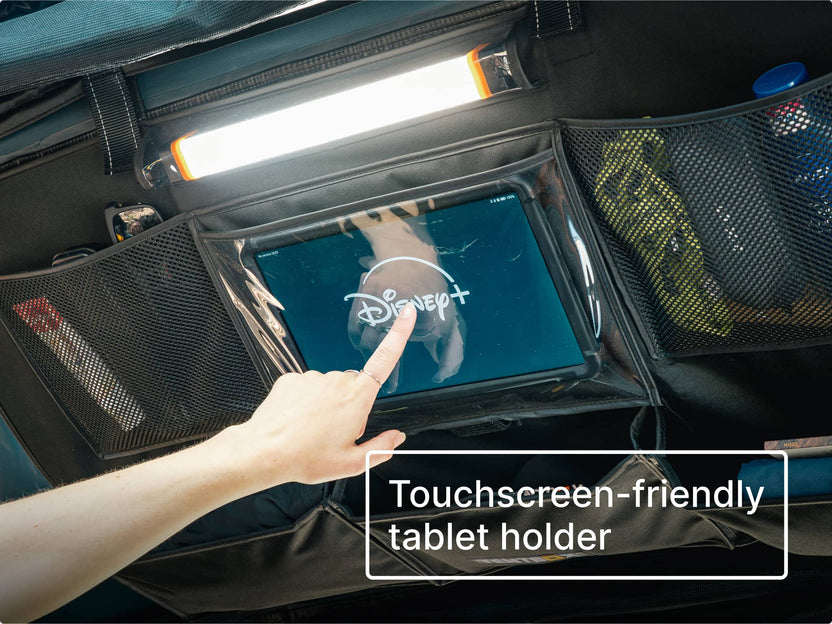 Touchscreen-friendly tablet holder on the Lite Storage Pockets with a hand pointing at a Disney+ app on the screen.