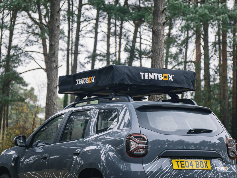 ATCLI - TentBox Lite 1.0 Travel Cover installed on a grey car in the woods