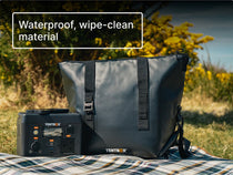 Black TentBox PowerStation and CoolBag on a picnic blanket in a grassy outdoor setting with text reading 'waterproof, wipe-clean material'.